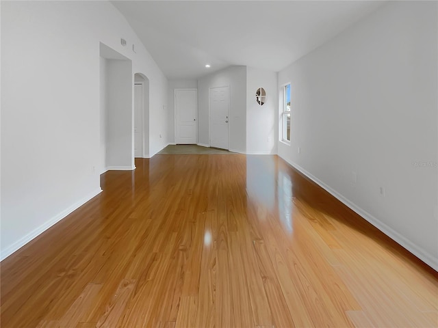 unfurnished living room with vaulted ceiling and light hardwood / wood-style flooring