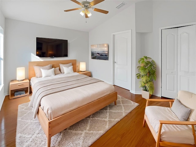 bedroom with dark hardwood / wood-style flooring, a closet, vaulted ceiling, and ceiling fan