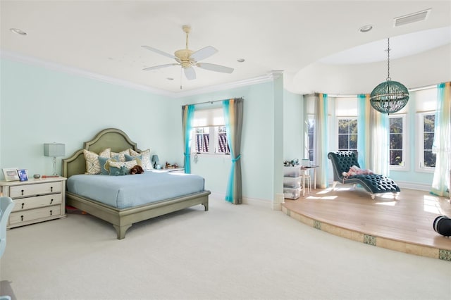 carpeted bedroom featuring ceiling fan with notable chandelier and ornamental molding