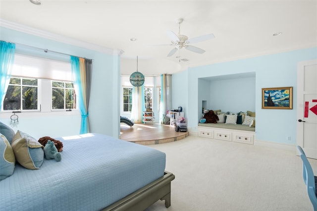 carpeted bedroom with ceiling fan and ornamental molding