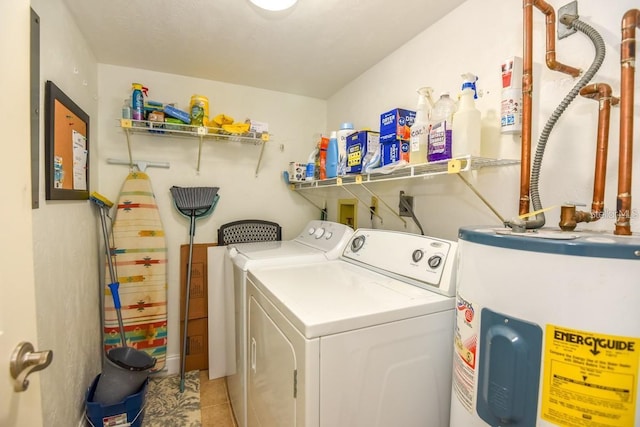 washroom with light tile patterned flooring, washing machine and dryer, and water heater