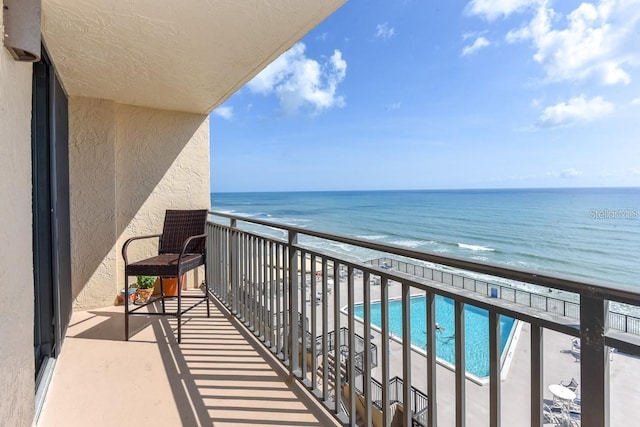 balcony featuring a water view and a view of the beach