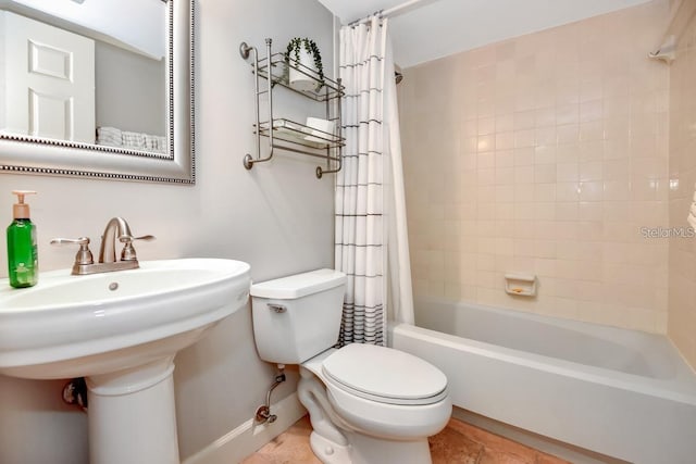 full bathroom with tile patterned floors, toilet, shower / bath combo with shower curtain, and sink