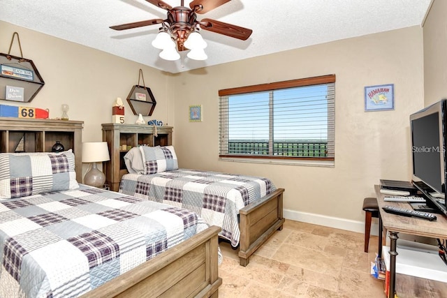 bedroom with ceiling fan and a textured ceiling