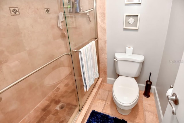 bathroom featuring toilet and a shower with shower door