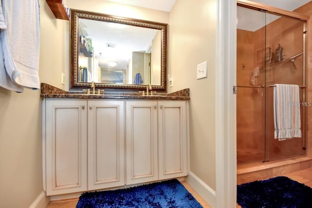 bathroom with a shower with door and vanity