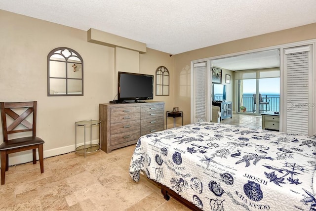 bedroom featuring access to exterior and a textured ceiling