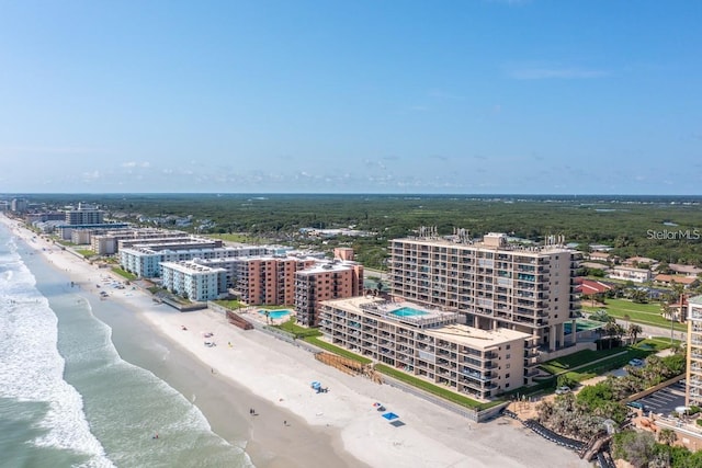 birds eye view of property with a water view and a beach view