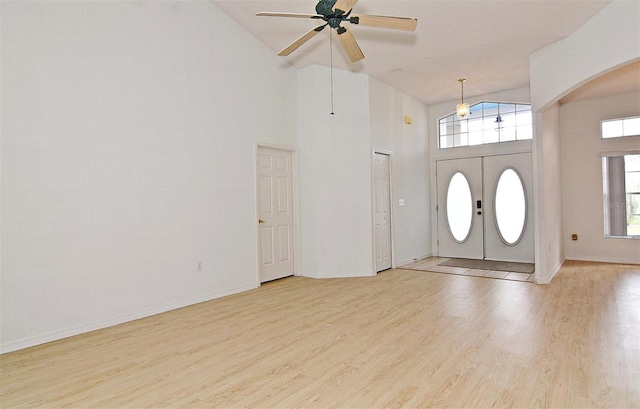 entrance foyer featuring ceiling fan, french doors, high vaulted ceiling, and light hardwood / wood-style flooring