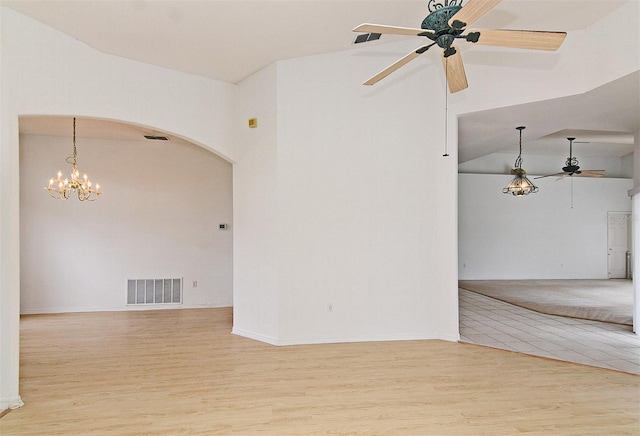 unfurnished room with lofted ceiling, light hardwood / wood-style flooring, and ceiling fan with notable chandelier