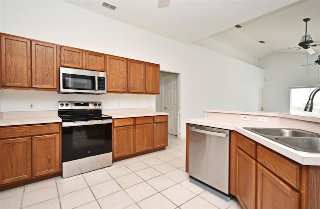 kitchen with stainless steel appliances, vaulted ceiling, ceiling fan, sink, and light tile patterned flooring