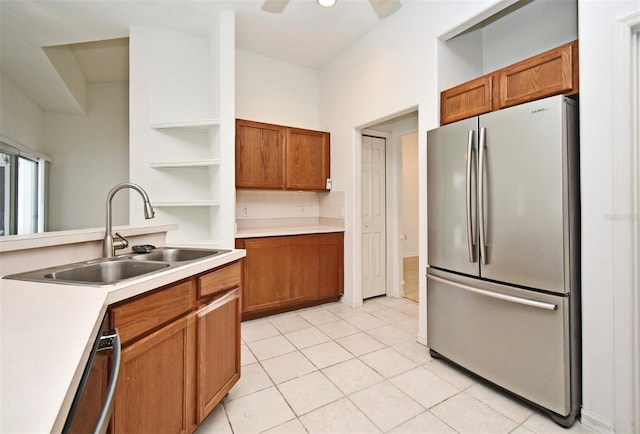 kitchen with appliances with stainless steel finishes, light tile patterned floors, ceiling fan, and sink