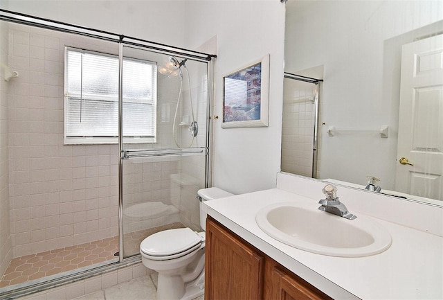 bathroom featuring tile patterned floors, vanity, toilet, and a shower with door