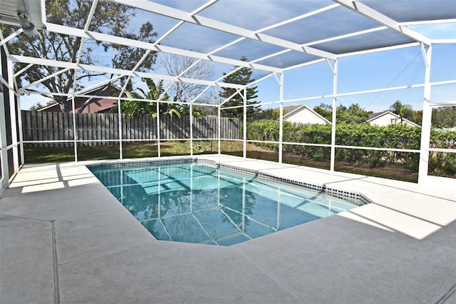 view of swimming pool featuring glass enclosure and a patio area