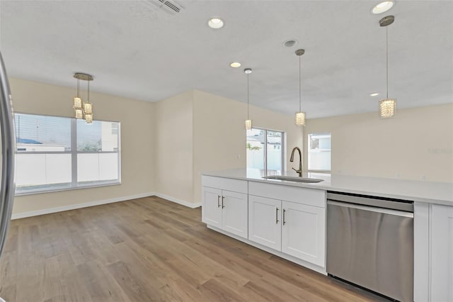 kitchen with dishwasher, pendant lighting, white cabinets, and sink