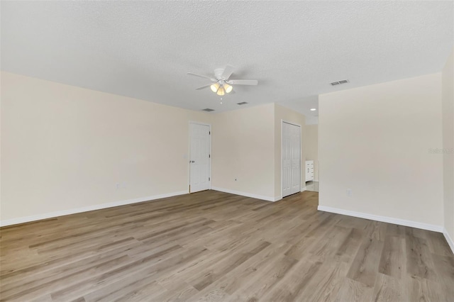 spare room featuring ceiling fan, light hardwood / wood-style floors, and a textured ceiling