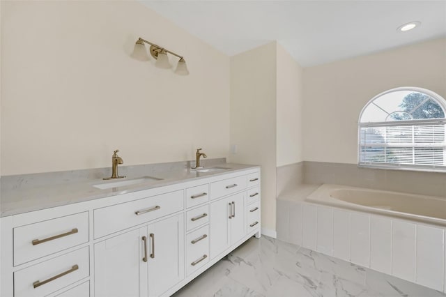 bathroom featuring vanity and a relaxing tiled tub