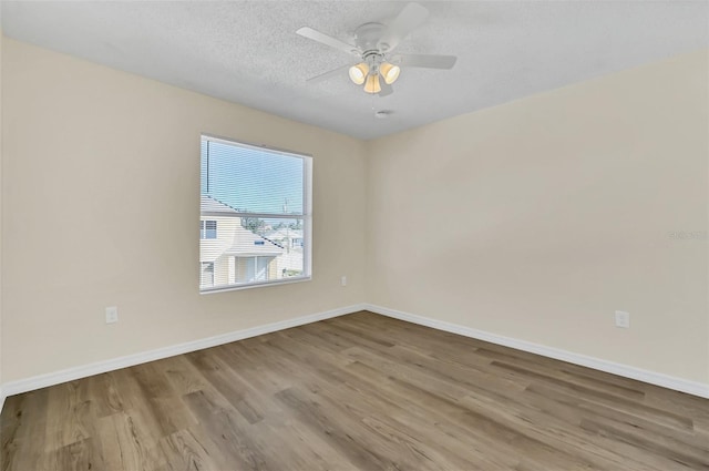 empty room with ceiling fan, a textured ceiling, and light wood-type flooring