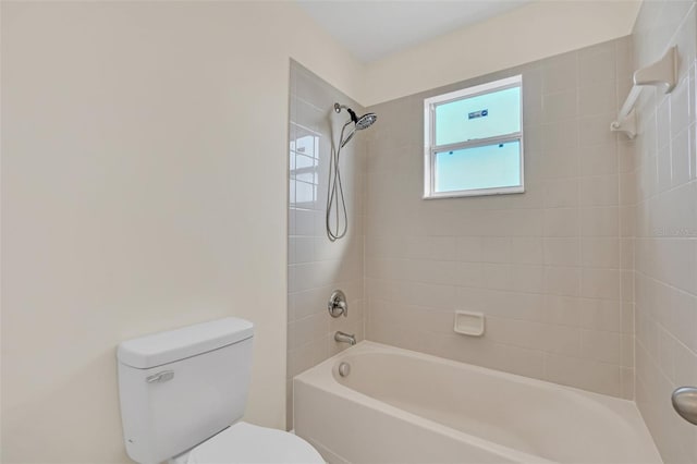 bathroom featuring tiled shower / bath combo and toilet