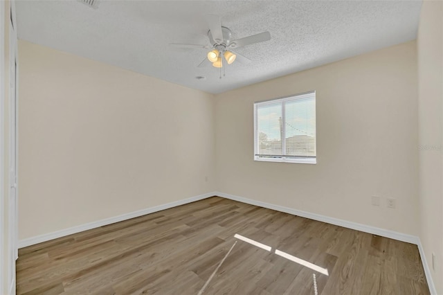 empty room featuring ceiling fan, a textured ceiling, and light wood-type flooring