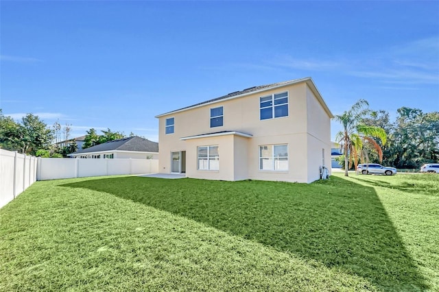 rear view of property featuring a patio area and a yard