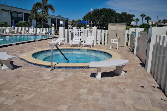 view of pool with a community hot tub and a patio area