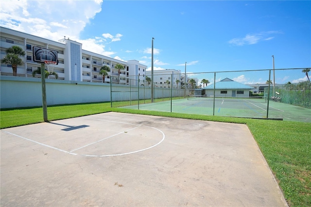 view of sport court with a lawn and tennis court