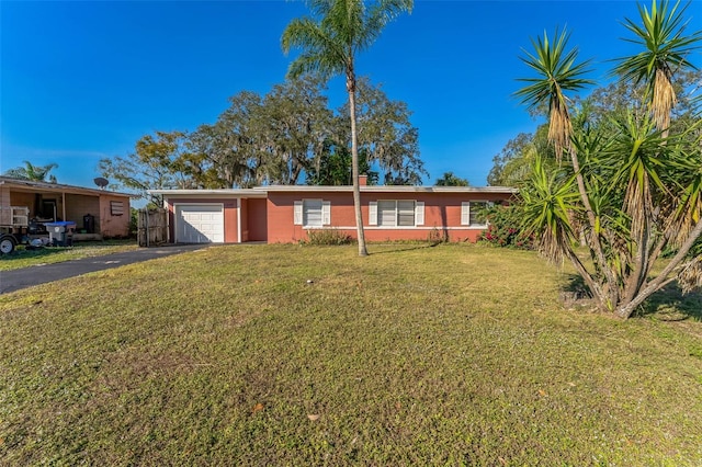 ranch-style home featuring a garage and a front lawn