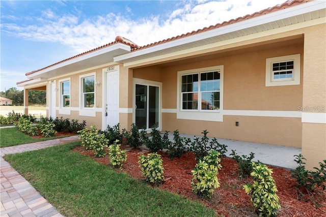 view of property exterior featuring a tile roof and stucco siding