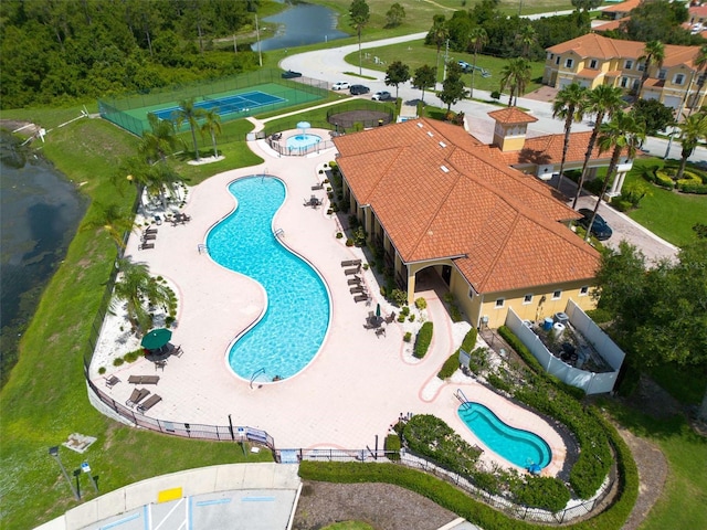 pool with a water view, fence, and a patio