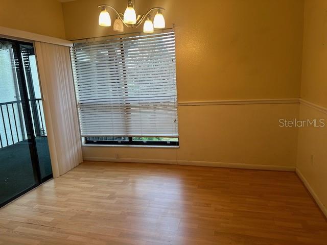 unfurnished room with hardwood / wood-style floors and a chandelier