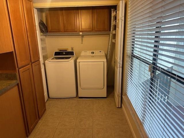 laundry room with cabinets, separate washer and dryer, and light tile patterned floors