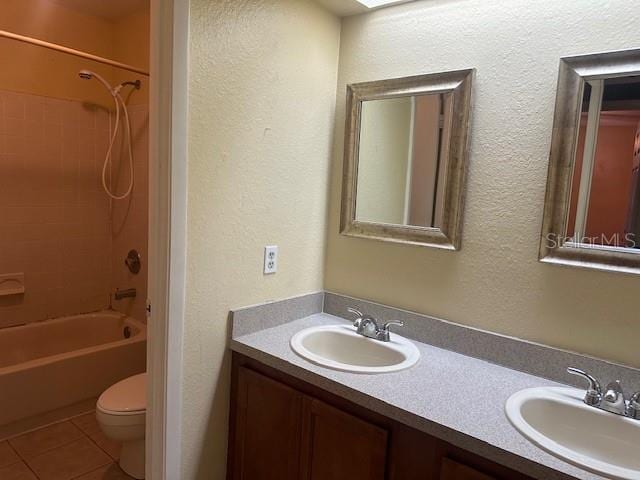 full bathroom featuring tile patterned floors, vanity, toilet, and shower / washtub combination