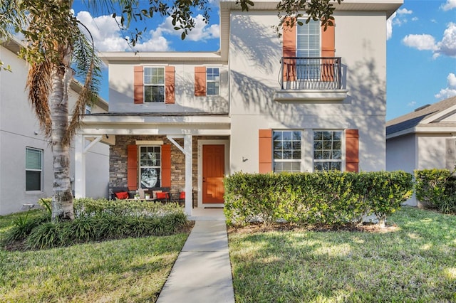 view of front of house featuring a front yard and a balcony