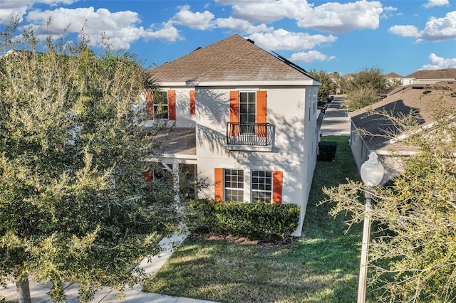 view of front of home with a front yard and a balcony