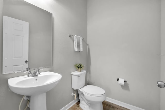 bathroom with hardwood / wood-style floors and toilet