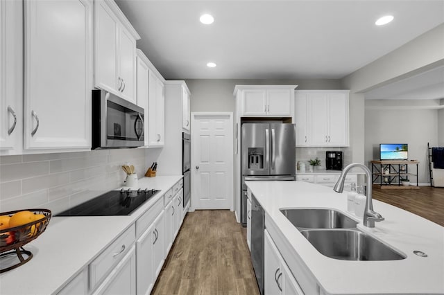 kitchen featuring tasteful backsplash, sink, white cabinets, and appliances with stainless steel finishes