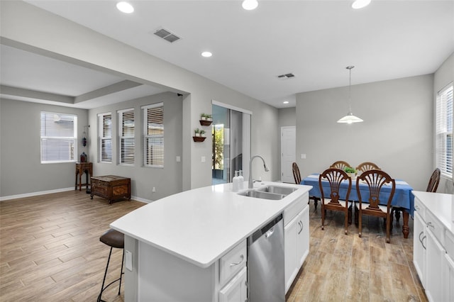 kitchen with dishwasher, sink, an island with sink, decorative light fixtures, and white cabinets