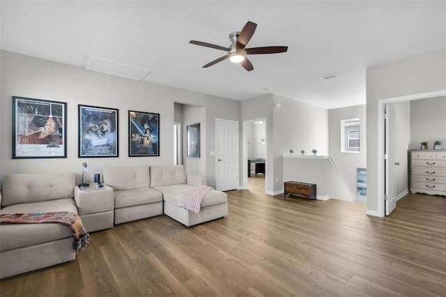 living room featuring wood-type flooring and ceiling fan