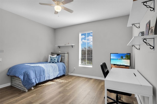 bedroom featuring hardwood / wood-style flooring, ceiling fan, and multiple windows