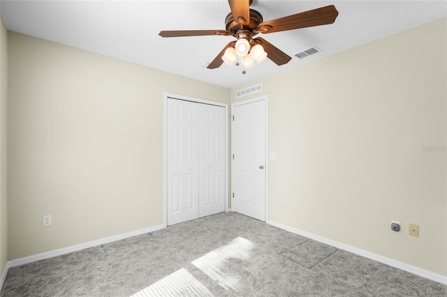 unfurnished bedroom with light carpet, a closet, and ceiling fan