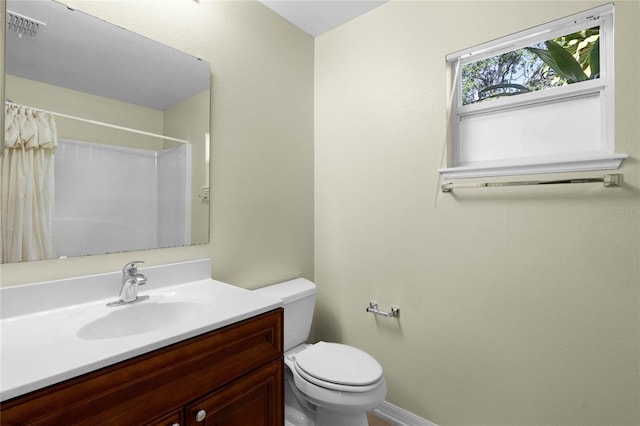 bathroom with walk in shower, vanity, and toilet