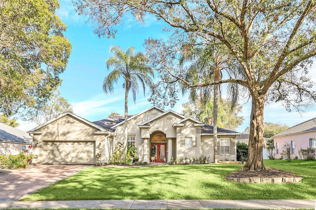 view of front of home with a garage and a front lawn