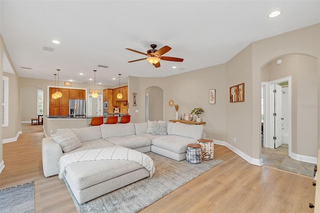 living room featuring light hardwood / wood-style flooring and ceiling fan