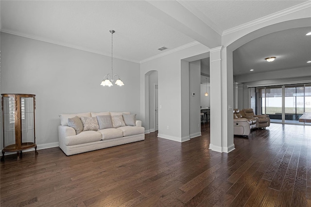 living room featuring ornamental molding, a textured ceiling, ornate columns, dark hardwood / wood-style flooring, and a chandelier