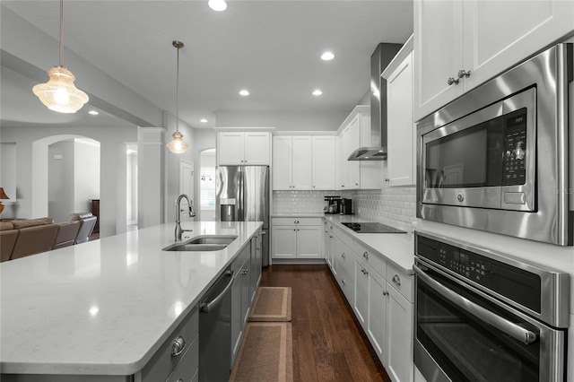 kitchen featuring pendant lighting, a center island with sink, sink, appliances with stainless steel finishes, and white cabinetry