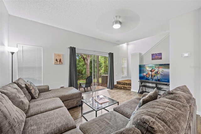 living room with ceiling fan, wood-type flooring, and a textured ceiling