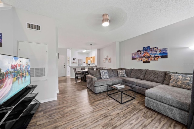 living room with wood-type flooring, a textured ceiling, and ceiling fan