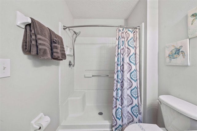 bathroom featuring curtained shower, a textured ceiling, and toilet