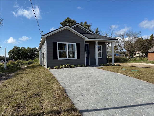 bungalow-style house featuring a front lawn